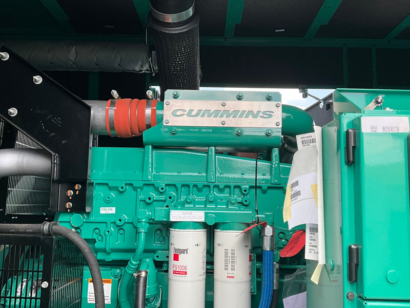 Load image into Gallery viewer, A green Cummins industrial diesel engine with visible filters, hoses, and a black intake pipe, photographed in a real mechanical setting rather than on a clean studio background.
